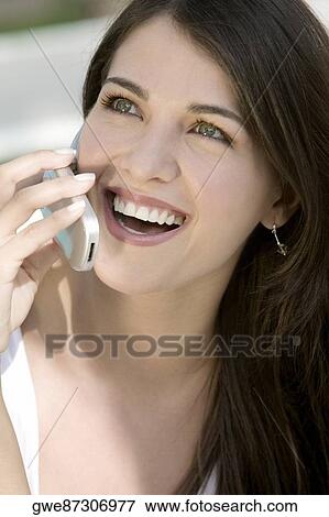 Close-up of a young woman talking on a mobile phone View Large Photo Image Stock Photo - Close-up of a young woman talking on a mobile phone. Fotosearch