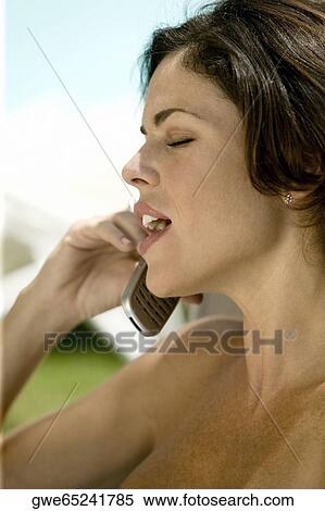 Close-up of a young woman talking on a mobile phone View Large Photo Image Stock Photography - Close-up of a young woman talking on a mobile phone. Fotosearch