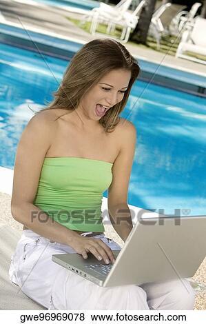 Close-up of a young woman using a laptop View Large Photo Image Stock Photo - Close-up of a young woman using a laptop. Fotosearch