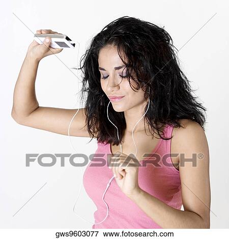 Stock Photo - Close-up of a young woman wearing headphones listening to music. Fotosearch