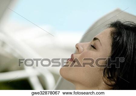 Stock Photo - Close-up of a young woman with closed her eyes. Fotosearch