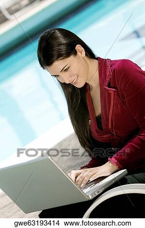 Close-up of a young woman working on a laptop View Large Photo Image Picture - Close-up of a young woman working on a laptop. Fotosearch