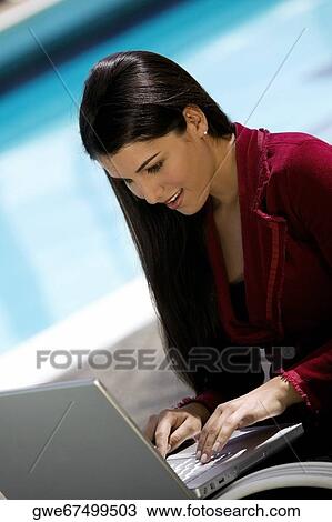Stock Image - Close-up of a young woman working on a laptop. Fotosearch
