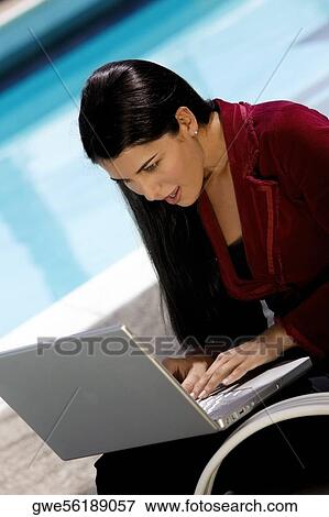 Close-up of a young woman working on a laptop View Large Photo Image Stock Photo - Close-up of a young woman working on a laptop. Fotosearch