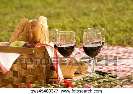 Stock Photo - Close-up of four glasses of red wine near a basket of bread. Fotosearch