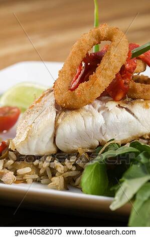 Stock Image - Close-up of rice and a fish fillet in a plate. Fotosearch