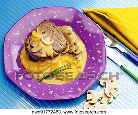Stock Image - Close-up of roast beef with mushrooms. Fotosearch