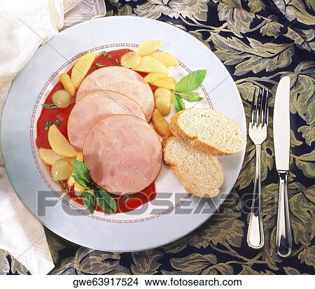 Picture - Close-up of sliced ham with sauce in a plate. Fotosearch