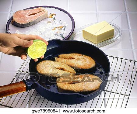 Stock Image - Close-up of sliced salmon frying in a pan. Fotosearch