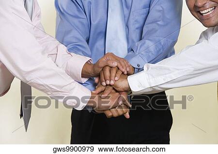 Stock Photo - Close-up of three businessmen shaking hands. Fotosearch