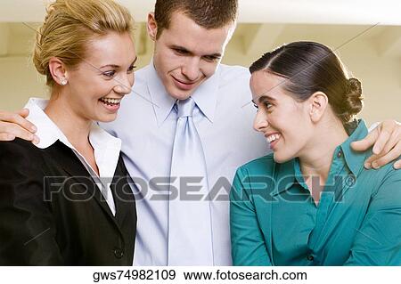 Stock Photo - Close-up of two businesswomen and a businessman smiling. Fotosearch