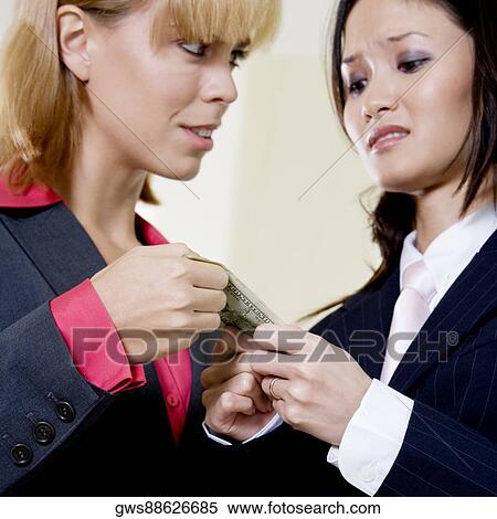 Close-up of two businesswomen holding a dollar bill View Large Photo Image Stock Photography - Close-up of two businesswomen holding a dollar bill. Fotosearch
