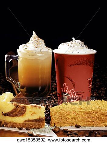 Stock Image - Close-up of two glasses of cappuccino with slices of cake. Fotosearch