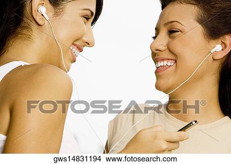 Close-up of two teenage girls listening to music with earphones View Large Photo Image Picture - Close-up of two teenage girls listening to music with earphones. Fotosearch