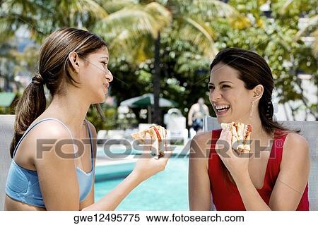 Close-up of two young women eating sandwiches View Large Photo Image Stock Photography - Close-up of two young women eating sandwiches. Fotosearch