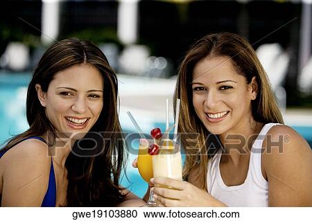 Close-up of two young women holding juice glasses View Large Photo Image Stock Image - Close-up of two young women holding juice glasses. Fotosearch