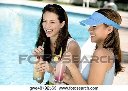 Close-up of two young women holding juice glasses View Large Photo Image Stock Image - Close-up of two young women holding juice glasses. Fotosearch