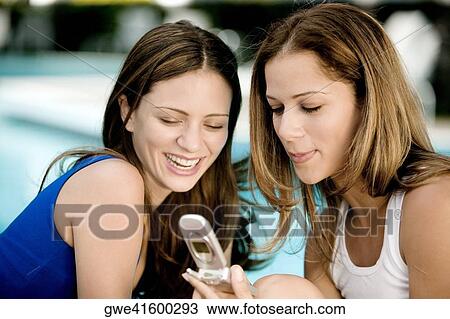 Close-up of two young women looking at a mobile phone View Large Photo Image Stock Image - Close-up of two young women looking at a mobile phone. Fotosearch