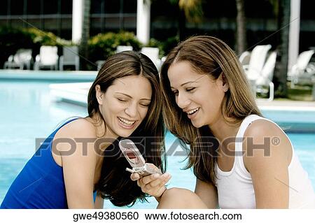 Close-up of two young women looking at a mobile phone View Large Photo Image Stock Image - Close-up of two young women looking at a mobile phone. Fotosearch