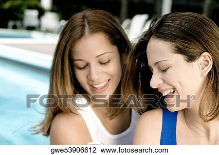 Close-up of two young women looking at a mobile phone View Large Photo Image Stock Image - Close-up of two young women looking at a mobile phone. Fotosearch