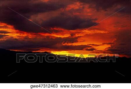Clouds over a mountain at sunset View Large Photo Image Stock Image - Clouds over a mountain at sunset. Fotosearch