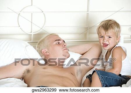 Father lying on the bed looking at his son View Large Photo Image Stock Photo - Father lying on the bed looking at his son. Fotosearch