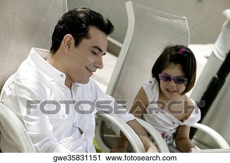 Father with his daughter sitting on armchairs View Large Photo Image Stock Image - Father with his daughter sitting on armchairs. Fotosearch