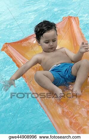High angle view of a boy floating on a pool raft View Large Photo Image Stock Photograph - High angle view of a boy floating on a pool raft. Fotosearch