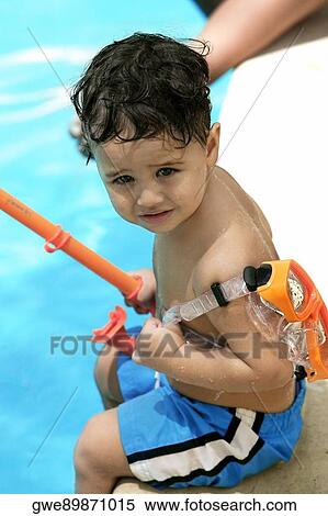 High angle view of a boy holding snorkel sitting by the pool View Large Photo Image Stock Photography - High angle view of a boy holding snorkel sitting by the pool. Fotosearch