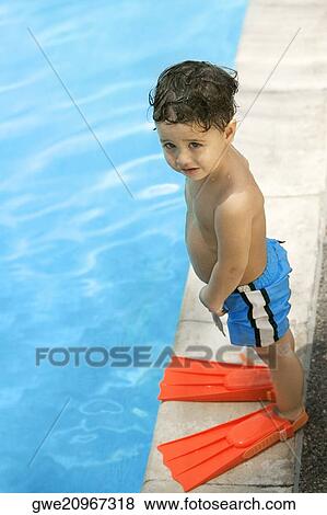High angle view of a boy standing by the pool View Large Photo Image Stock Photo - High angle view of a boy standing by the pool. Fotosearch
