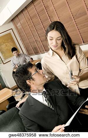 High angle view of a businessman and a businesswoman sitting in an office View Large Photo Image Stock Photo - High angle view of a businessman and a businesswoman sitting in an office. Fotosearch