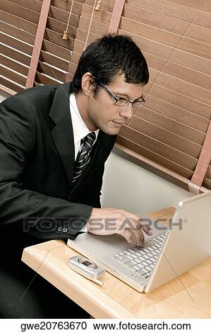 Stock Image - High angle view of a businessman using a laptop. Fotosearch