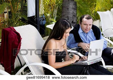 Stock Photo - High angle view of a businesswoman and a businessman working on a laptop. Fotosearch