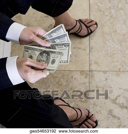 High angle view of a businesswoman counting American paper currency View Large Photo Image Stock Image - High angle view of a businesswoman counting American paper currency. Fotosearch