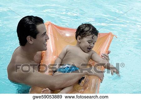 High angle view of a father with his son in a swimming pool View Large Photo Image Stock Photo - High angle view of a father with his son in a swimming pool. Fotosearch