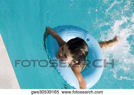 Stock Photography - High angle view of a girl swimming with an inflatable ring. Fotosearch