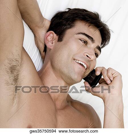 High angle view of a mid adult man talking on a mobile phone View Large Photo Image Picture - High angle view of a mid adult man talking on a mobile phone. Fotosearch