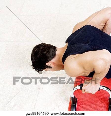 Stock Image - High angle view of a mid adult man doing push-ups. Fotosearch