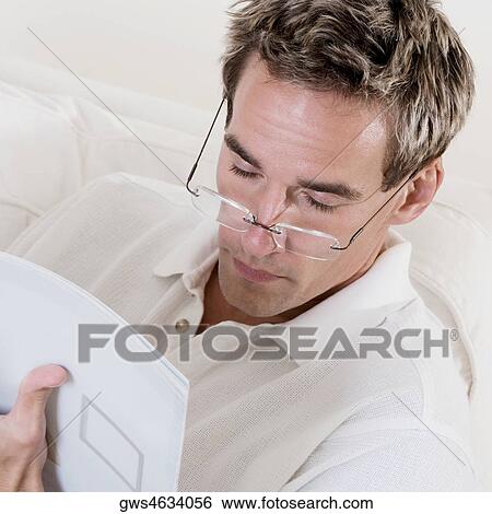 High angle view of a mid adult man reading a book View Large Photo Image Stock Photograph - High angle view of a mid adult man reading a book. Fotosearch