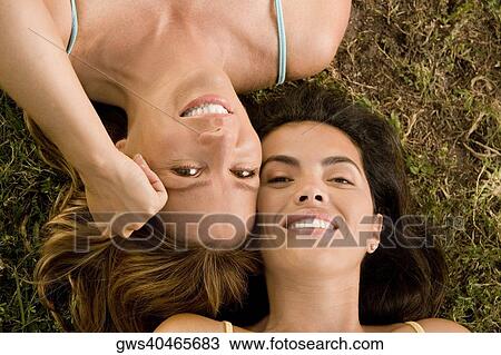 High angle view of a mid adult woman and a mature woman lying on the grass View Large Photo Image Stock Image - High angle view of a mid adult woman and a mature woman lying on the grass. Fotosearch