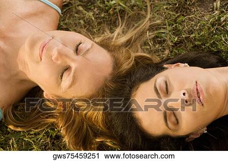 High angle view of a mid adult woman and a mature woman lying on the grass View Large Photo Image Stock Image - High angle view of a mid adult woman and a mature woman lying on the grass. Fotosearch
