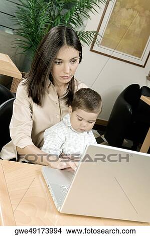 High angle view of a mother using a laptop with her son View Large Photo Image Picture - High angle view of a mother using a laptop with her son. Fotosearch
