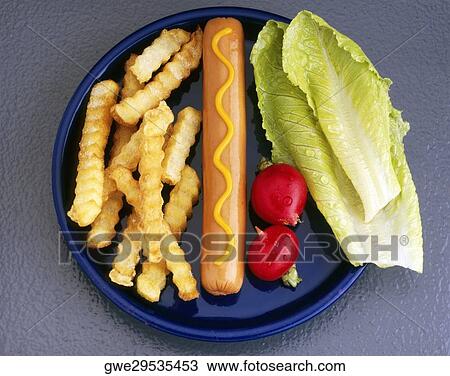 Stock Image - High angle view of a sausage with french fries and lettuce leaves on a plate. Fotosearch
