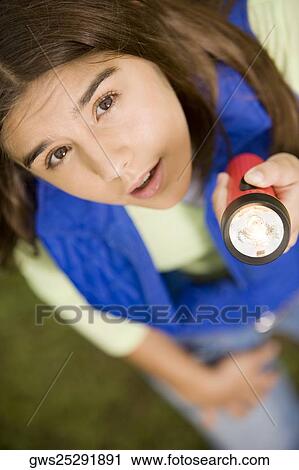 High angle view of a teenage girl holding a torch light View Large Photo Image Stock Image - High angle view of a teenage girl holding a torch light. Fotosearch