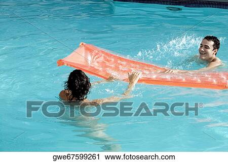 High angle view of a young couple in a swimming pool View Large Photo Image Stock Image - High angle view of a young couple in a swimming pool. Fotosearch
