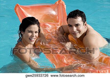 Stock Photograph - High angle view of a young couple in a swimming pool. Fotosearch