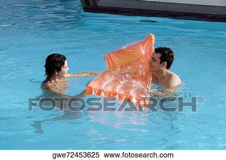 High angle view of a young couple in a swimming pool View Large Photo Image Stock Photography - High angle view of a young couple in a swimming pool. Fotosearch