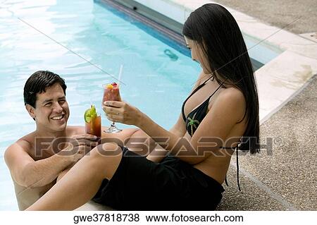 Stock Photo - High angle view of a young couple raising a toast. Fotosearch