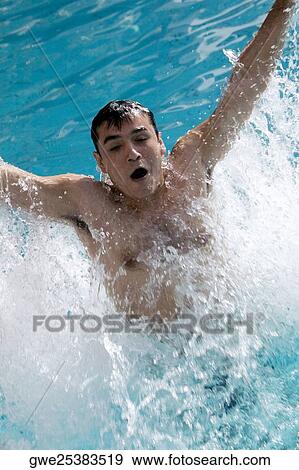 High angle view of a young man splashing water in a swimming pool View Large Photo Image Stock Photo - High angle view of a young man splashing water in a swimming pool. Fotosearch