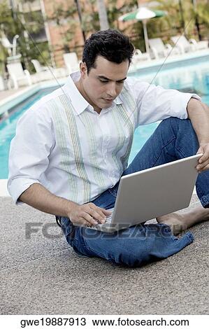 High angle view of a young man using a laptop View Large Photo Image Stock Image - High angle view of a young man using a laptop. Fotosearch
